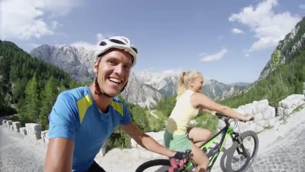 Selife Lächelnde Junge Paar Mit Ihren Fahrrädern Auf Einer Bergstraße — Stockvideo