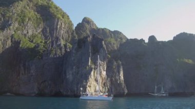 Pov, Lens Flare: Pitoresk Koh Phi Phi Lee etrafında doğal gezi turları turistleralarak geçmiş demirli yelkenli hız. Nefes kesen kireçtaşı kayalıklar demirli turist tekneler için gölge sağlamak