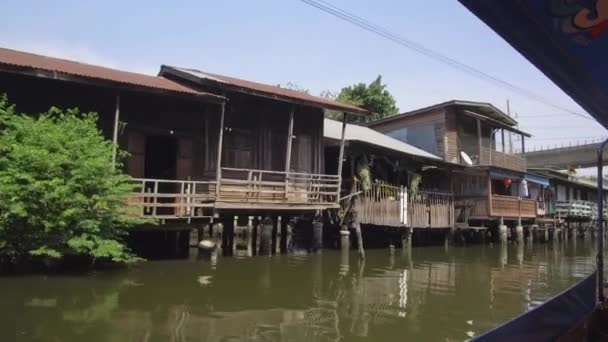 Niedrige, triste Holzhäuser, die neben verschmutzten Flüssen in Thailand stehen. schmutzige und stinkende chao phraya Fluss fließt vorbei an armen Gegend von Bangkok, dient als Touristenattraktion für Sightseeing-Touren.
