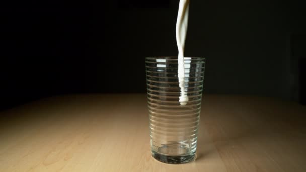 Super Slow Motion Delicious Cold Milk Loured Empty Glass Wooden — стоковое видео