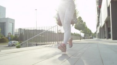 Yavaş Hareket Yakın Lensflare Tanınmayan genç kadın büyük bir şehirde sabahın erken saatlerinde koşu bir spor kıyafeti içinde. Atletik kız iş yerinde bir gün sonra egzersiz. Sağlıklı yaşam tarzını benimseyen kadın
