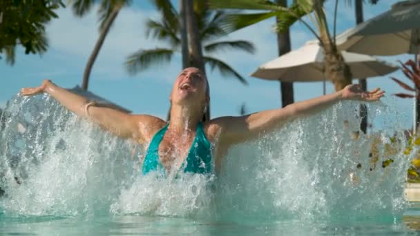 慢动作 在美丽的池畔度假胜地 水下的白种人游客胜利地伸出双臂 在温暖的夏日早晨站起水面 兴奋的年轻女子泼水 — 图库视频影像