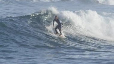 Yavaş Hareket: Deneyimli sörfçü adam deniz kenarında güneşli bir günde büyük bir mavi çökme dalgası üzerinde oyma. Aşırı surfboarder geri ada plaja kristal berraklığında dalga sürmek. Spor yaparken sörf yaparken eğleniyor.