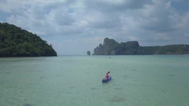 Phi Phi Adaları popüler turistik nokta yakınında Hava Genç Kafkas kadın kano. Yaz tatilinde aktif kız Tayland tropikal adacıklar etrafında onu kayık kürekler. Serin kayak gezisinde kadın turist