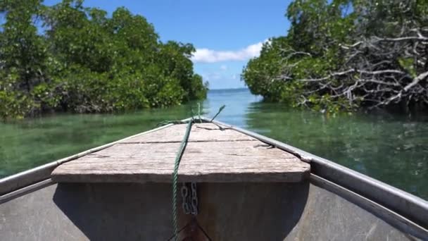 POV : Monter en bateau en bois à travers le canal de couleur émeraude sur une île exotique ensoleillée. Verdure tropicale pittoresque entoure beau canal menant petit bateau vers la vaste mer ouverte près de Vanuatu .