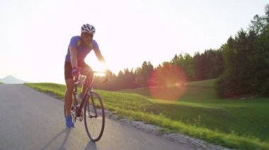 Yavaş Hareket, Lens Flare, Kopya Alanı: Atletik adam güneşli yol bisiklet yarışı nın başarılı bitirmek kutluyor. Pro Kafkas yol bisikletçisi doğal manzara genelinde zorlu eğitim yarışı bitirmek için mutlu.
