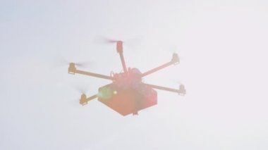 Closeup Lens Flare İhA drone mal teslim. Kargo multicopter ile son dakika hediye teslimatı. Evinize doğum günü hediyesi getiren drone'u gönderiyor. Fütüristik drone güneş üzerinde Noel hediyesi uçan