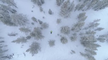 Aerial Close Up Taze karda yatan tanınmayan genç kadın kar açılar yapıyor. Noel'den önce kış neşesi. Mistik kış harikalar diyarında oynayan sıcak kış giysileri neşeli kız