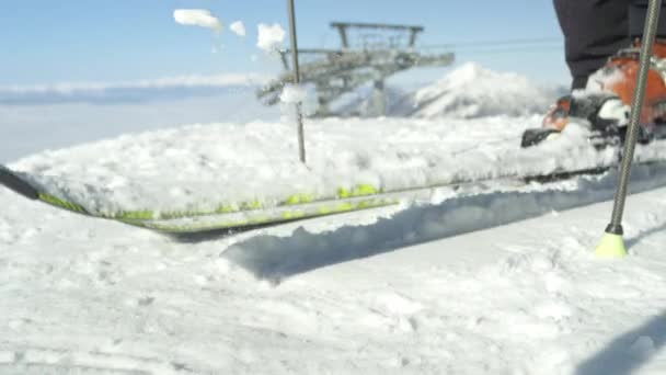 慢动作特写 滑雪者在雾中从山顶上的滑雪板上清除新雪 滑雪场位于欧洲阿尔卑斯山畔 冬季阳光明媚 万里无云 后背的现代滑雪升降 — 图库视频影像