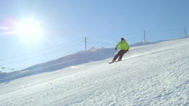 Yavaş hareket eden kayakçı, soğuk kış mevsiminde sakin ve mükemmel havanın tadını çıkarıyor. Kayak merkezinde kayak pistinde tek başına kayak yapmak. Dağın tepesinde..