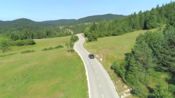 牧歌的な田舎の風景の空の国の高速道路に沿って運転ブラックSuv車 美しい緑のスロベニアを横断するロードトリップの人々 遠い谷の緑豊かな丘と草原 — ストック動画