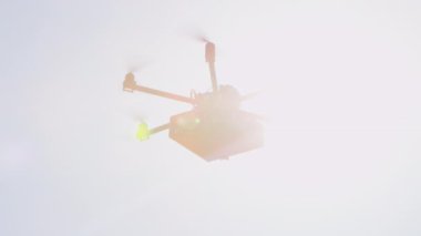 Closeup Lens Flare İhA drone mal teslim. Kargo multicopter ile son dakika hediye teslimatı. Evinize doğum günü hediyesi getiren drone'u gönderiyor. Fütüristik drone güneş üzerinde Noel hediyesi uçan