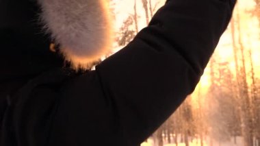 Slow Motion, Close Up: Gün doğumunda soğuk kış gününde karla oynayan neşeli genç kadın. Havakar taneleri atan oyuncu kız. Güneşli sabah zevk kış ceket gülümseyen kadın portresi