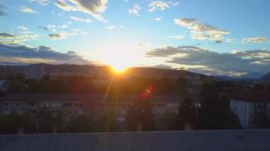 Hava konut gökdelenler, bloklar, daireler, evler ve evler üzerinde güzel kentsel şehirde muhteşem altın gündoğumu ormanlık dağlarla çevrili uçan. Güneşli sabah Ljubljana cityscape