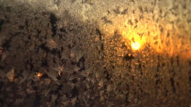 Close Up Dof: Altın yükselen güneşte parıldayan buzlu pencerede güzel buzlu çiçekler. Kış gün doğumunda parıldayan pencere camındaki boğuk buz kristalleri. Donmuş pencereden kış gün batımına bakmak.
