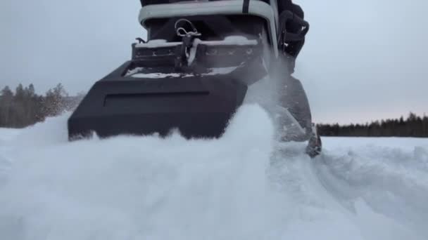 スローモーション クローズアップ スノーモービルが離陸し カメラに雪をスプレーします バックカントリーでのそり乗馬レース スノーモービルは 回転し 新鮮な雪を蹴り上げ 雪片を吹き付けます スノーモービル — ストック動画