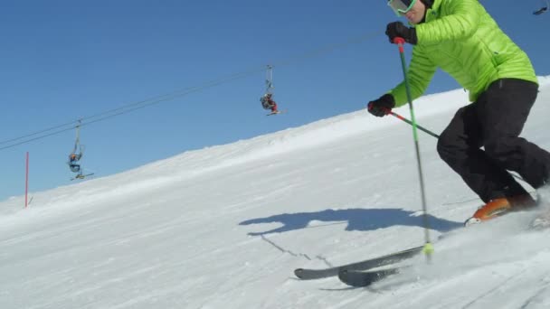 Tracking Zeitlupe professionelle Skifahrer genießen Erholung bei idyllischem perfektem Wetter an einem kalten Wintertag zum Skifahren auf steilen, frisch präparierten Pisten. Skigebiet in den Alpen in Europa.
