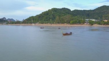 Krabi, Tayland - Mart 2017, Hava: Tayland longtail tekne tur rehberi kalabalık Railay plajdan uzakta onun ahşap gemi yolculukları. Kumlu sahilde yaz tatilinin tadını çıkaran bir sürü insan.