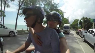 Krabi, Tayland - Mart 2017, Selfie: Genç Kafkas çift Asya'da bir sahil köyü üzerinden bir scooter sürmek. Erkek arkadaşı ve kız arkadaşı harika bir yaz tatil yolculuğu güneşli bir yolda bir motosiklet.