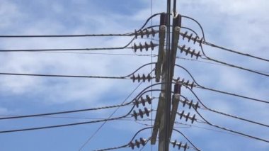 Close Up: Beton elektrik direği parlak mavi yaz gökyüzüne kuleleri. Tayland'da yakındaki kasabalara elektrik sağlayan Tall telgraf sonrası. Güneşli bir caddenin üzerinde çalışan tehlikeli güç kabloları.