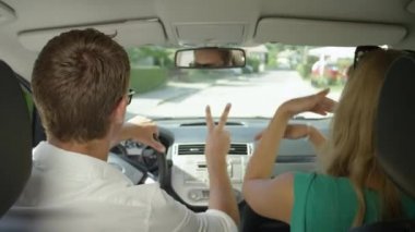 Slow Motion, Close Up: Güneşli banliyölerde araba sürerken heyecanlı genç çiftler dans ediyor. Neşeli turistler yolculuk boyunca eğleniyorlar. Erkek arkadaş ve kız arkadaş sürüşün tadını çıkarıyor..