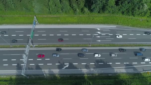 自上而下 五颜六色的车辆沿着繁忙的高速公路和混凝土立交桥移动 在汽车和卡车上空飞来飞去 在一条穿过绿色自然的繁华公路上来回行驶 — 图库视频影像