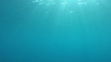 Slow Motion, Sualtı: Parlak güneş ışınları Tahiti yakınlarında berrak ve berrak okyanus yüzeyinde parlıyordu. Sıcak tropikal yaz güneşinde parlayan turkuaz deniz suyunun güzel görüntüsü..