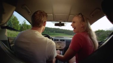 Slow Motion, Close Up: Güzel sarı saçlı beyaz kadın yakışıklı erkek arkadaşını öptükten sonra yürekten gülerek onları güneşli bir akşamda manzaralı kırsal alanda gezdiriyor..