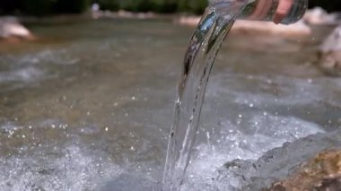 Ters Yavaş Hareket, Kapat: Cam gibi su, dağ deresi boyunca yürüyen tanınmayan birinin elinde bulunan büyük şeffaf bardağa geri akar. Bilinmeyen kız nehre su döktü..