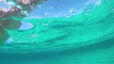 Slow Motion, Half Sualtı, Pov: Güneşli İtalya 'da uzak bir adada yüzerken boğulmak. Genç erkek turist denizde kayboldu. Nefes nefese kaldı ve kıyıya çıkmaya çalışırken su sıçrattı.
