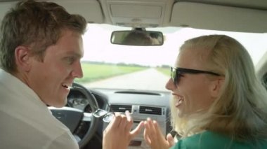 Slow Motion, Close Up: Neşeli, genç, beyaz bir çift kırsal alanda gezinirken dans ediyor. Kız arkadaş ve erkek arkadaş güneşli bir günde yolculuklarında eğleniyorlar..