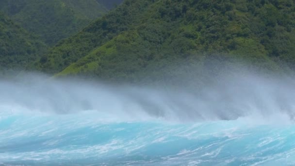 ゆっくりとした動き 閉じる 強力なターコイズブルーの上から水を吹いている強い熱帯の風は 太平洋の遠くの島に向かって砕けていきます 緑豊かなエキゾチックな島に近づく危険な海の波 — ストック動画