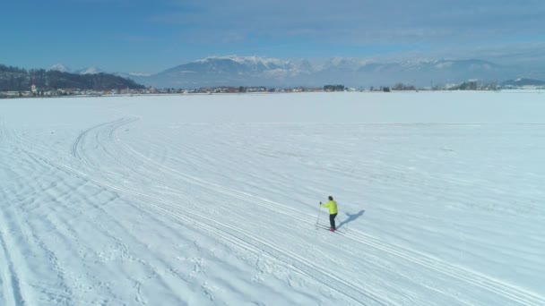 在阳光明媚的冬日里 在白雪中沿着狭窄的小道滑雪的活跃女子身后飞行 斯洛文尼亚冬季景观和女子旅游滑雪越野的电影观 — 图库视频影像