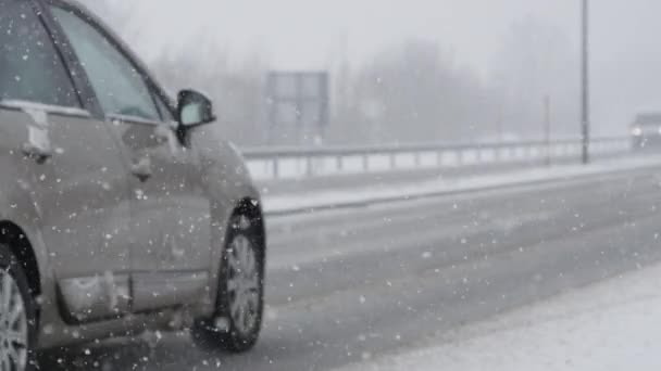 慢动作 在暴风雪中在雪地的高速公路上航行的车辆 电影拍摄的白色雪花从黑暗的天空中坠落下来 使道路变得危险和滑 — 图库视频影像