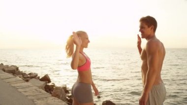 Slow Motion, Close Up: Okyanus kıyısındaki yaz tatilleri sırasında eğlenceli bir yaz egzersizinden sonra mutlu çift beşliği çakıyor. Başarılı erkek ve kadın egzersizleriyle bitirmeyi kutluyorlar..