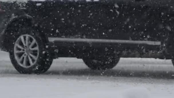 慢动作 在暴风雪期间 汽车车轮向空中吐出肮脏的雪 在暴风雪中 通勤者慢慢地沿着雪地的道路行驶 田园诗般的冬日 道路崎岖 — 图库视频影像