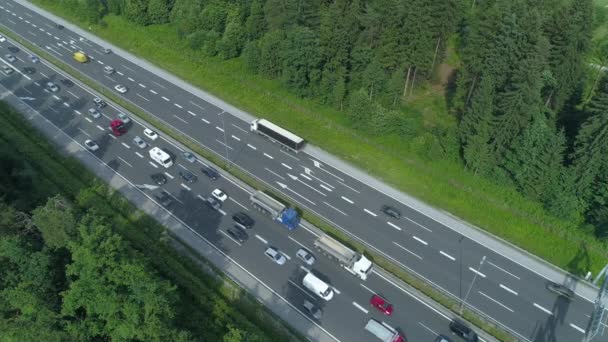 无数的汽车和卡车在斯洛文尼亚通过生动的绿色森林的高速公路上穿过一个瓶颈 上班族和游客在严重的交通堵塞中穿行 — 图库视频影像