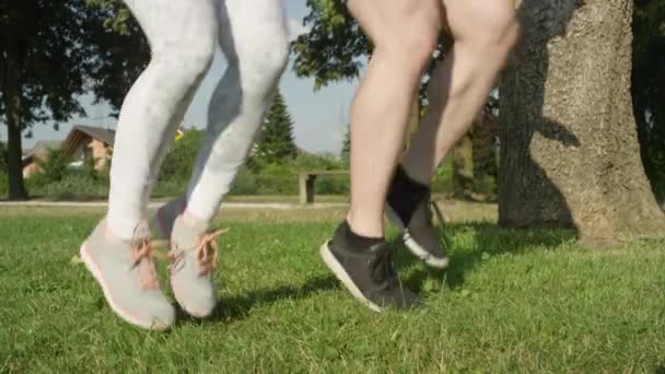 慢动作 低角度 无法辨认的男女运动员在自然界中跑步 一对不认识的夫妇在公园里锻炼 享受夏天 男友和女朋友培训 — 图库视频影像