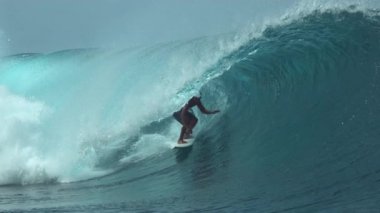 Slow Motion, Close Up: Extreme erkek sörfçü muhteşem Teahupoo, Tahiti 'de destansı bir zümrüt varil dalgasıyla geziyor. Genç adam güzel tüp dalgalarında sörf yaparak aktif tatilinin tadını çıkarıyor..