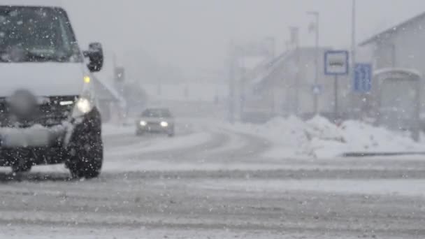 慢动作 在极端天气状况下 城市交通穿过一个交叉口 小镇的沥青路面上覆盖着猛烈的暴风雪 汽车驶过白雪飞扬的柏油路 — 图库视频影像