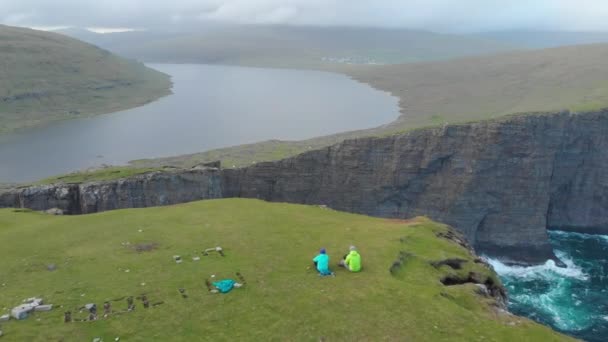 Anténa Dva Turisté Nepoznání Sedí Velké Louky Pozorování Jezera Nedaleko — Stock video