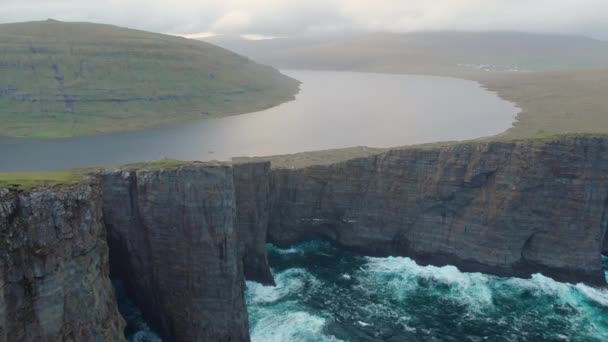 Aerial Pequeños Turistas Sentados Alto Acantilado Cubierto Hierba Observando Majestuoso — Vídeo de stock