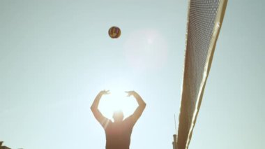 Slow Motion, Close Up, Low Angle, Lens Flare: Atletik erkek voleybol oyuncusu topu siyah ağa fırlatıyor ve sayı yapamıyor. Tatil sırasında plaj voleybolu oynayan sağlıklı beyaz adamlar..