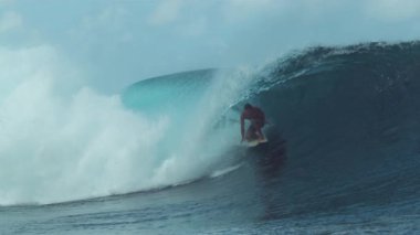 Slow Motion, Close Up: Extreme erkek binicisi güneşli Tahiti 'de sörf yaparken büyük bir zümrüt renkli tüp dalgası yakalıyor. Popüler bir sörf yerinin yakınında sörf yapan adam mükemmel bir varil dalgası boyunca kıyıya doğru koşuyor..