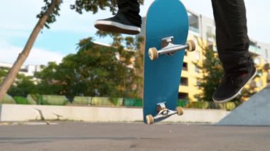 Slow Motion, Close Up: Genç erkek kaykaycı güneşli bir günde kaykay parkında değişik bir takla atıyor. Tanımlanamayan bir erkek sporcunun mavi kaykayıyla güzel bir gösteri yaptığı sinematik çekim..