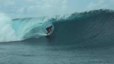 Slow Motion, Close Up: Extreme Surfboardcu güneşli Teahupoo, Tahiti 'de destansı bir zümrüt varil dalgası sürüyor. Profesyonel sörfçü büyüleyici Fransız Polinezyası 'nda epik kristal berrak tüp dalgalarını sürerken eğleniyor..