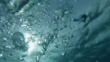 Slow Motion, Sualtı, Pov: Tahiti yakınlarındaki kristal berrak okyanusun dibine batıyor. Büyük hava kabarcıkları denizin kristal berrak yüzeyinde parlayan parlak güneş ışığına doğru süzülür..