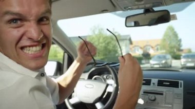Slow Motion, Close Up: Genç beyaz erkek güneşli banliyölerde işe giderken kuduruyor. Trafik sıkışıklığında yürürken kızgın sürücü arabasında bağırıyor. Kızgın adam trafiğe bağırıyor..
