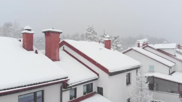 Aerial Volando Sobre Casa Fila Cubierta Nieve Hacia Bosque Invernal — Vídeos de Stock