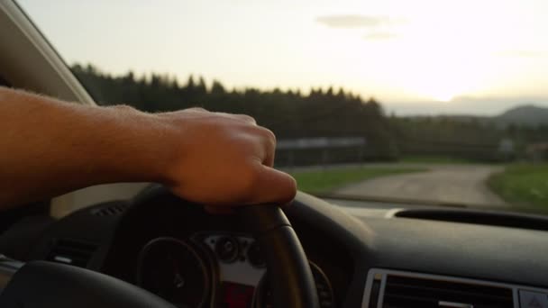 スローモーション クローズアップ Dof 未知の男性ドライバーは壮大な夏の朝に牧歌的な田舎を通って車を操縦します 認識できない若い男が夕日の空の田舎道を巡航 — ストック動画